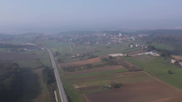 Letecký pohled na vysoké nadmořské výšce zemědělské půdy v blízkosti vesnice Cresnjevec v krajině Slovinska na mlhavé ráno — Stock video