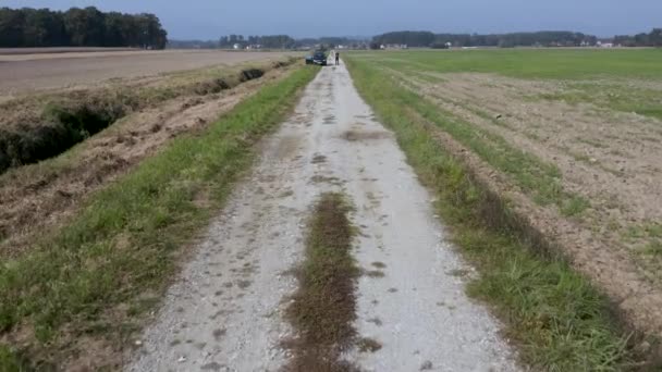 Filmati di droni che volano veloci e vicino alla superficie di una strada vuota e sopra un uomo nella Slovenia rurale — Video Stock