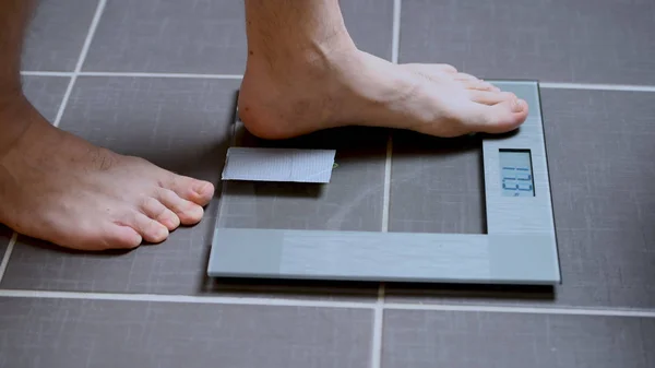 Male feet on glass scales, mens diet, body weight
