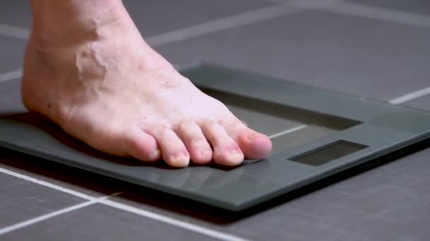 Mannelijke voeten op glazen schalen, mens voeding, lichaamsgewicht — Stockvideo