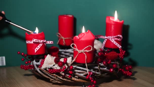 Couronne de Noël moderne avec quatre bougies rouges sur une surface en bois avec fond vert — Video