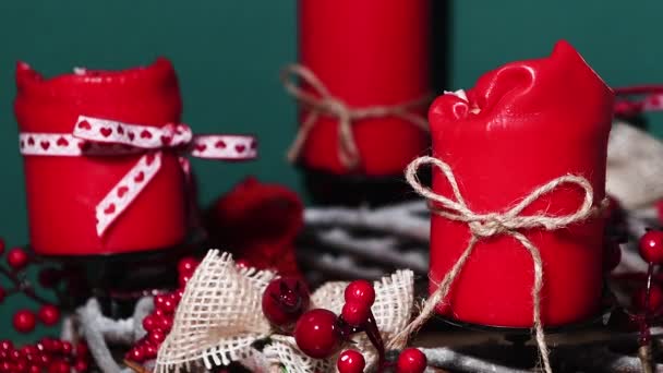 Moderner Adventskranz mit vier roten Kerzen auf Holzfläche mit grünem Hintergrund — Stockvideo