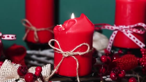 Corona de Navidad moderna con cuatro velas rojas en la superficie de madera con fondo verde — Vídeos de Stock