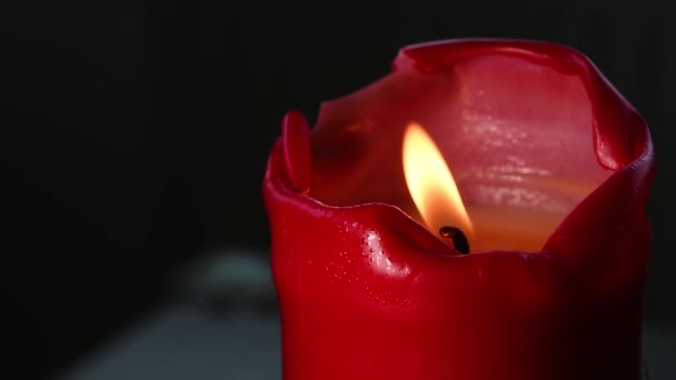 Einzelne rote Kerze auf dunklem teal Hintergrund — Stockvideo