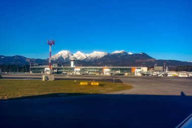 Ljubljana Airport asfalt, terminal ve arka planda dağlar