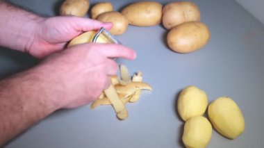 Mans eller mutfak soyucu ile patates soyma
