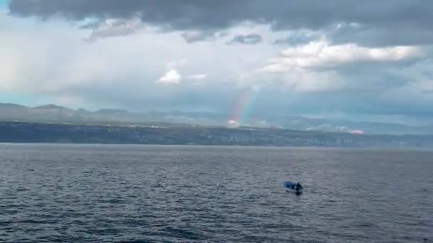 Arco-íris acima de pequeno barco de pesca em trovoada — Vídeo de Stock