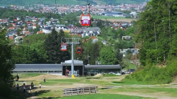 Люди путешествуют на нижней станции канатной дороги на горе Поорье в Мариборе, Словения летом — стоковое видео
