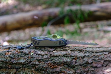 Victorinox İsviçre Askerleri Bıçak Model 08, ormanda ağaç gövdesi üzerinde genişletilmiş testere bıçak ile standart ordu sorunu modeli