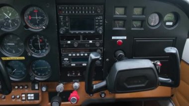 Hafif spor uçak kabininde pilot oynayan küçük çocuk, uçan çocukluk hayalleri, gösterge paneli closeup ve kontrolleri hareketli