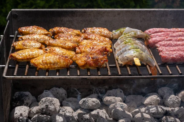 Змішаний асортимент маринованого м'яса, курки та креветок на грилі на гарячому вугіллі на барбекю — стокове фото