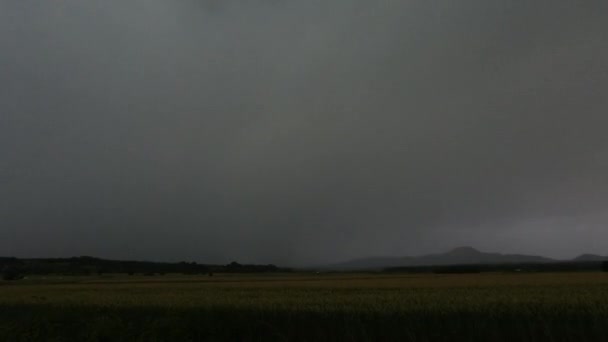 Trovoada em tempo real com relâmpagos iluminando o céu acima da paisagem rural, clima extremo e mudanças climáticas — Vídeo de Stock