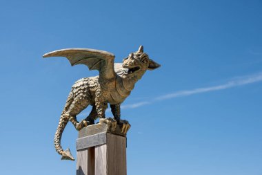 Mavi gökyüzünde izole kutup üzerinde bronz ejderha heykeli