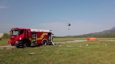 Askeri helikopter su kovasıyla yangınla mücadele ediyor