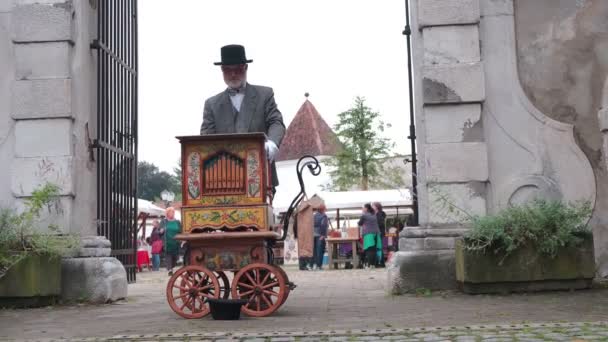 Człowiek gra uliczne organy na targach — Wideo stockowe