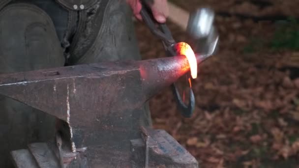 Blacksmith forging heart shaped iron on anvil, closeup, nobody — Stock Video