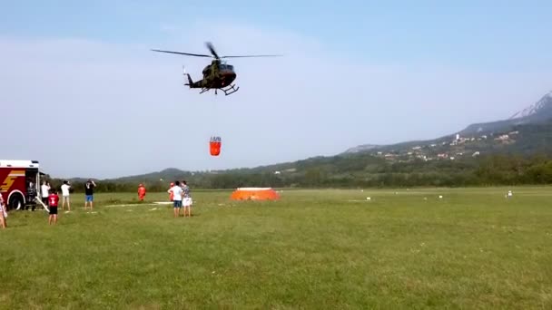 Военный вертолет борется с огнем с ведром для воды — стоковое видео