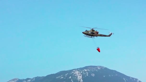 Militaire helikopter vechten vuur met een water emmer — Stockvideo