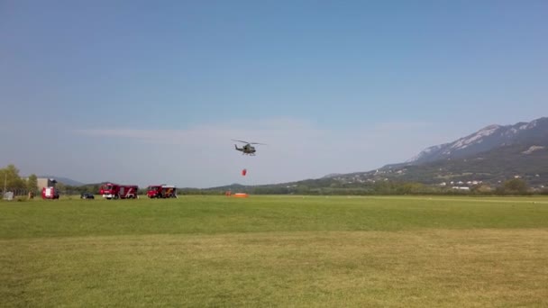 Military helicopter fighting fire with a water bucket — Stock Video