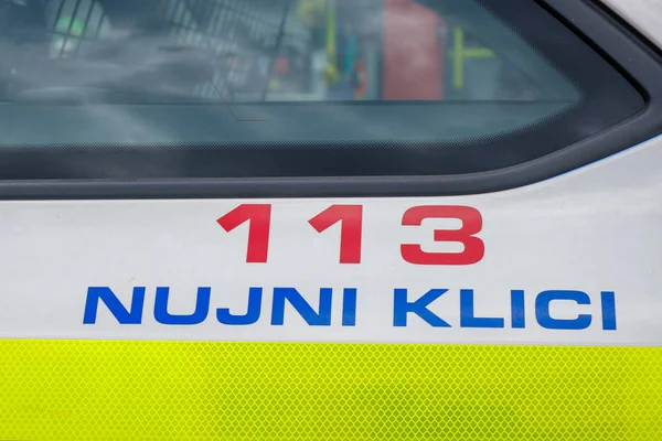 Policejní značka s číslem tísňového volání na straně hlídkového vozu — Stock fotografie