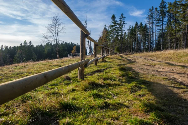 Hiking trail in mountains with wooden fence along the path Stock Picture