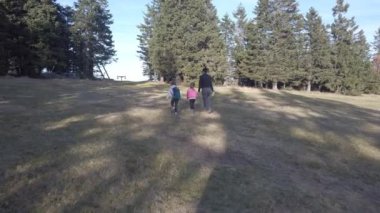 Anne ve iki kızı doğa yürüyüşü yapıyor.