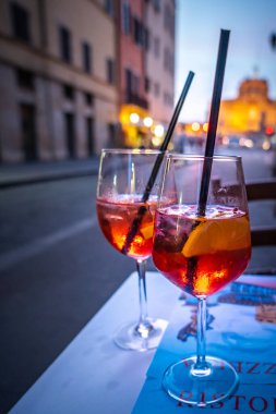 Campari Aperol Spritz kokteyli Roma 'daki Kutsal Melek Kalesi manzaralı kafe / restoran masasında. Geleneksel İtalyan aperatifi Prosecco ve likör Campari.