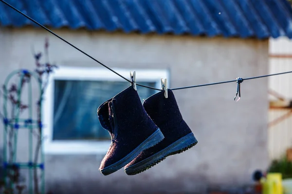 felt boots dried on a stretched clothesline in the yard