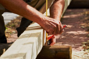 İnşaat sırasında bir inşaat açısı, bir cetvel ve bir kalem kullanarak parametrelerin ölçümü.