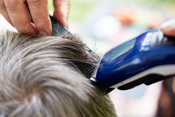 clipping gray hair with a clipper