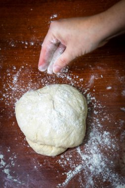 Kadın ellerinin ev yapımı ekmek için para kazandığını görürüz.