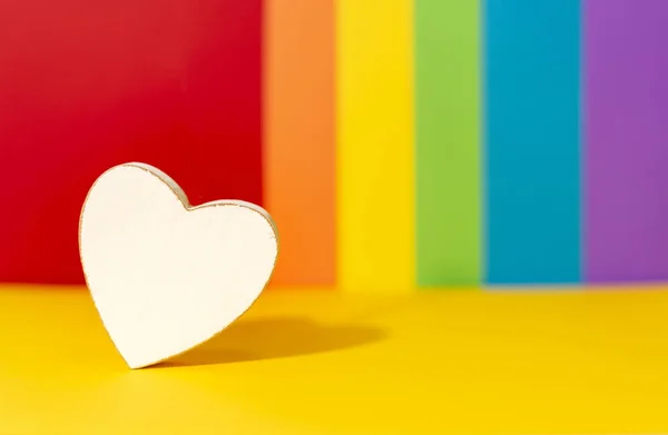 Beyaz tahta kalp arka planda LGBT hareketinin renkleriyle. LGBT hareket bayrağı renkleri