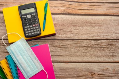 Okul malzemeleri ve koronavirüs önleyici maddeler. Mavi bir arka planda alt sınır. Salgın konsepti sırasında okula dönmek