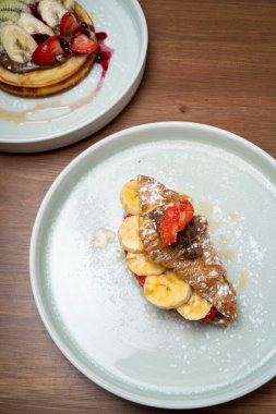 Taze meyve ve çikolata kaplı tatlı kruvasan, waffle tatlısıyla servis edilir.