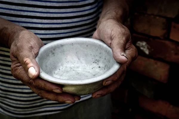 Zavallı yaşlı adamın elleri boş bir kase tutuyor. Açlık ya da yoksulluk kavramı. Seçici odak. Emeklilikte yoksulluk. Evsiz. Sadaka