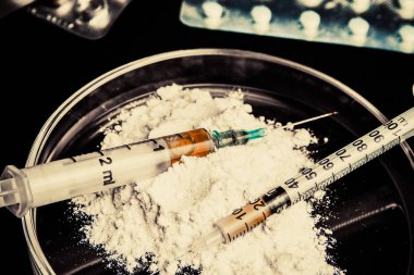 Karanlık masada uyuşturucu ve şırıngalar var. Opioid salgını .
