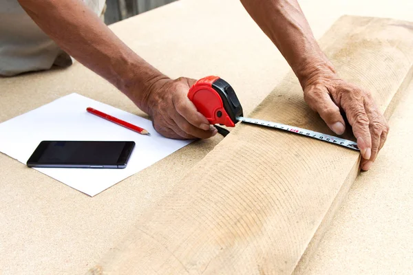 Carpenter inspect the quality of the material and calculate the