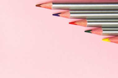 Pastel pembe arka plan üzerinde renkli kalemler. Trend renkleri, Desen