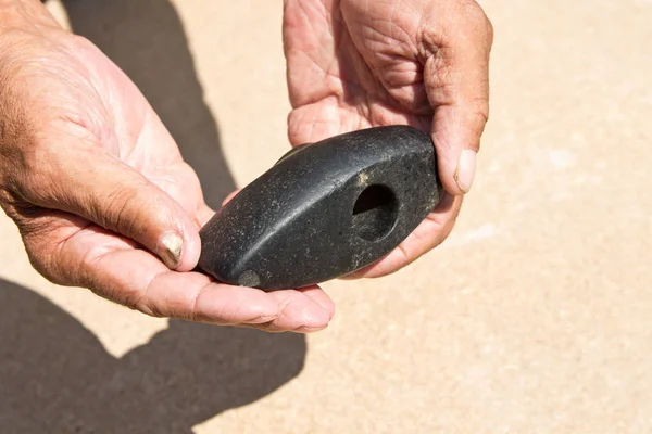 Stary kamień Hammer starszy człowiek trzyma w dłoniach. Archeologia — Zdjęcie stockowe