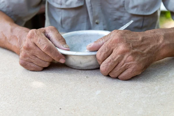 Hungry. Poor old man's hands an empty bowl. Selective focus. Pov — Stock Photo, Image