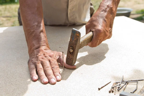 El hombre se golpeó el dedo con un martillo. carpintería profesional, wo Imagen de archivo