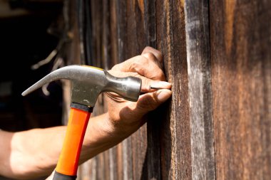 Çekiçle çivi çakmak için. Yaşlı işçi marangoz