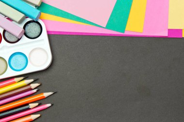 Okul ve ofis malzemeleri tahtada. Renkli kağıt, kalem