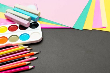 Okul ve ofis malzemeleri tahtada. Renkli kağıt, kalem