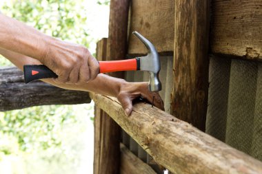 Çekiçle çivi çakmak için. Yaşlı işçi marangoz