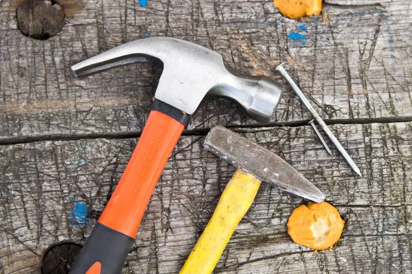 Martillo y clavos esparcidos sobre fondo de madera. Concepto de carpintería — Foto de Stock