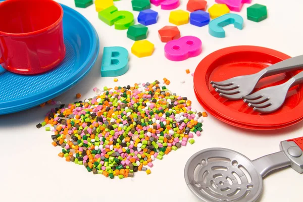 Plastic granules disposable tableware and children's toys made o — Stock Photo, Image