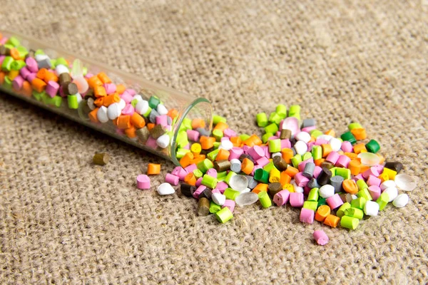 Plastic pellets .Polymeric dye in test tubes on gray background. — Stock Photo, Image
