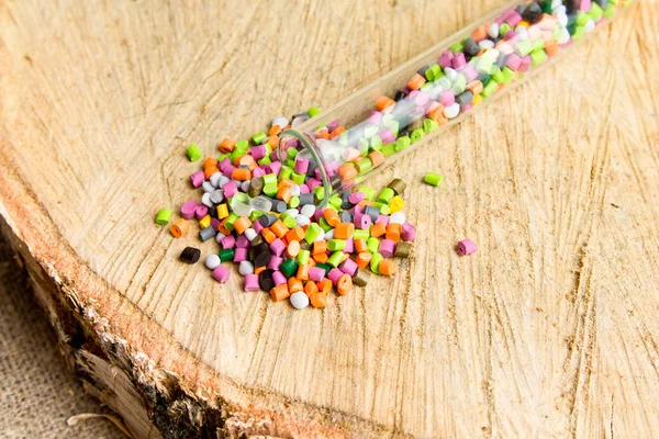 Plastic pellets .Polymeric dye in test tubes on gray background.