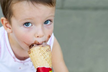 Küçük çocuk, yaz aylarında dondurma yiyor. Şirin yürümeye başlayan çocuk dondurma yeme. Kirli yüzü dondurma yiyen çocuk